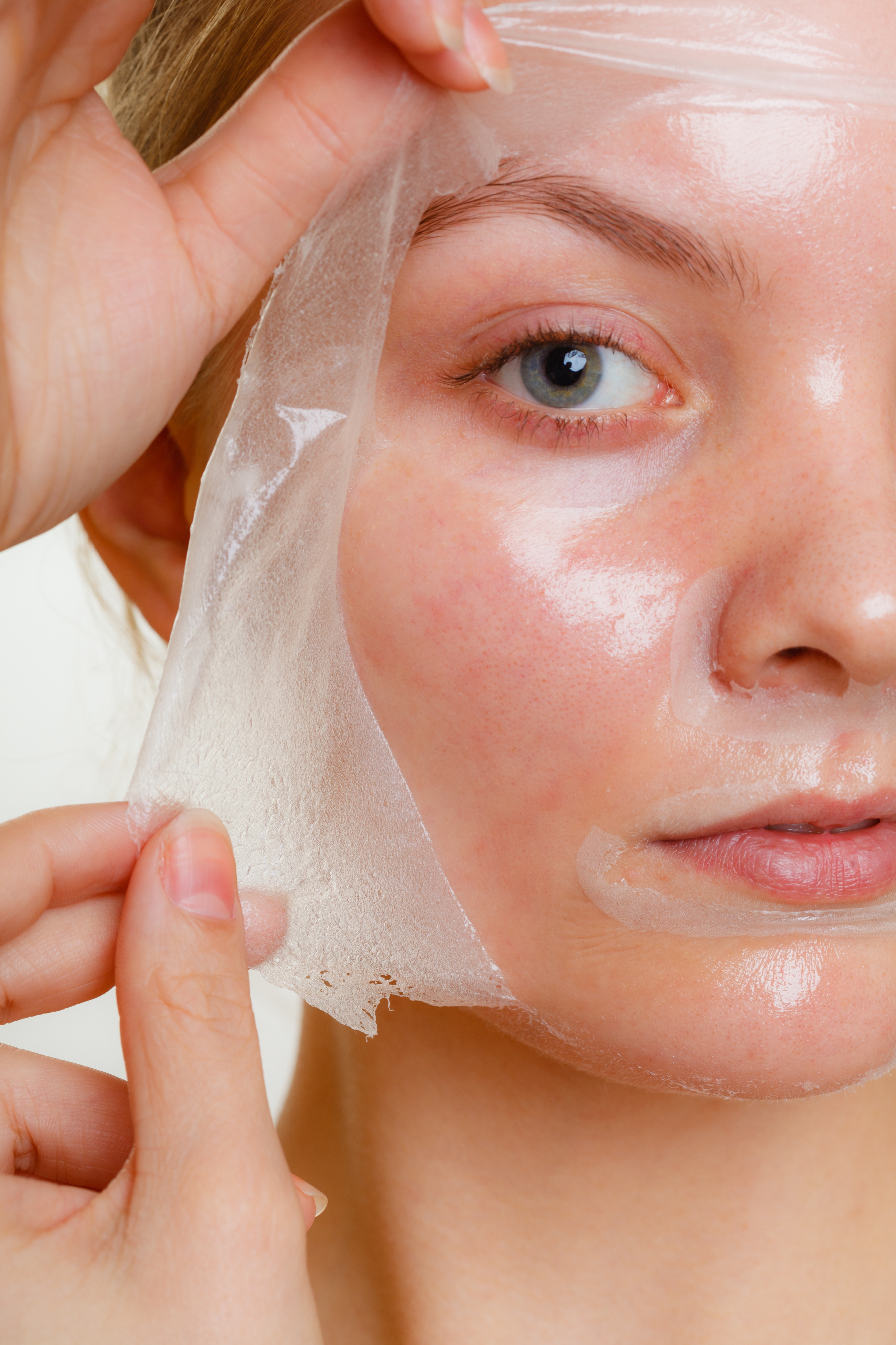 Woman removing facial peel off mask.